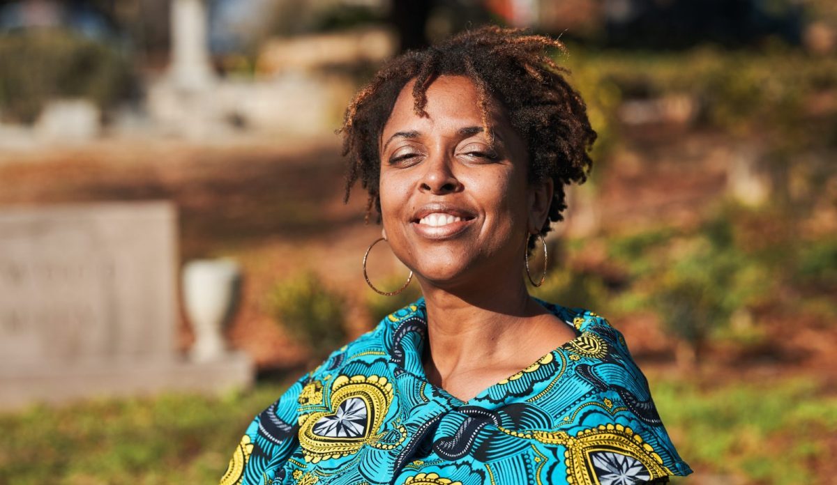 Photo of Charmaine Minniefield sitting in Oalkand Cemetery