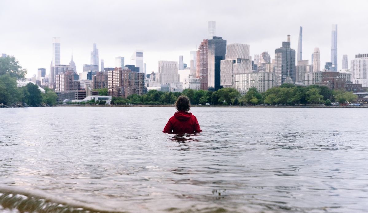 Image of artist Sarah Cameron Sunde standing in the rising tide in New York City's Estuary