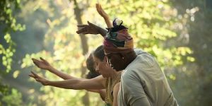 Three dancers in a line with their arms outstretched